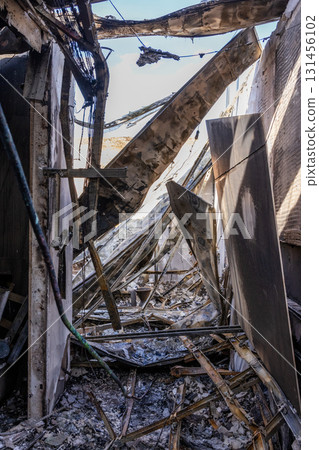 War. The aftermath of Russian airstrikes on a peaceful Ukrainian city. A hospital and a recreation center were destroyed. Fire damaged interior with charred beams, broken roof, and scattered debris. War. The aftermath of Russian airstrikes on a peaceful Ukrainian city. A hospital and a recreation center were destroyed. Fire damaged interior with charred beams, broken roof, and scattered debris. 131456102