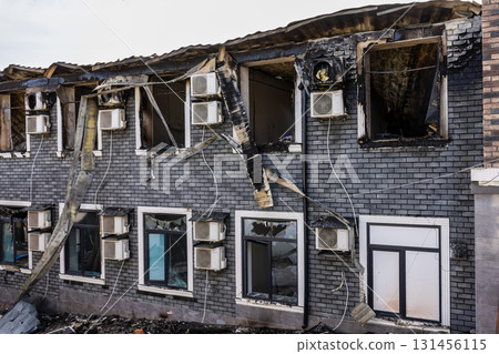 Bila Tserkva, Kyiv region, Ukraine - 09.06.2025: War. The aftermath of Russian airstrikes on a peaceful Ukrainian city. Burned brick building with charred upper floor, broken roof, and debris. 131456115