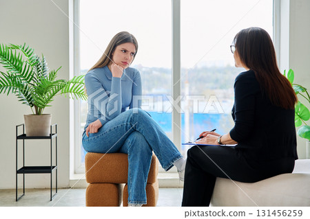 Young woman in a therapy session talking with a psychotherapist Young woman in a therapy session talking with a psychotherapist 131456259