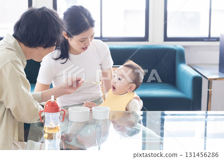 A couple feeding their baby food 131456286