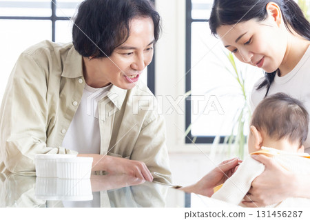 Young couple making baby eat baby food 131456287