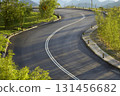 Winding road curving through green mountain landscape 131456682