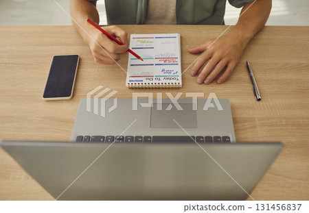 Man Planning Day in Notebook With Pencil Man Planning Day in Notebook With Pencil 131456837