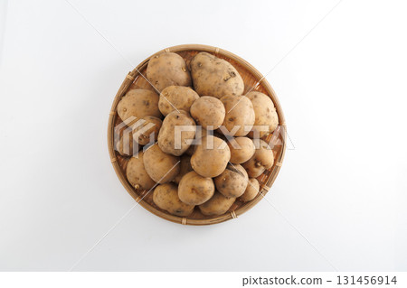 Fresh potatoes with mud in a colander 131456914