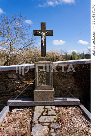 Beautiful Jesus Christ on crucifix, cemetery on a sunny day, spring, Easter, new life and religion concept 131457176
