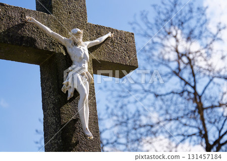 Beautiful Jesus Christ on crucifix, cemetery on a sunny day, spring, Easter, new life and religion concept 131457184