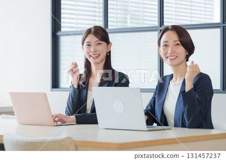 一位商人和一位女士正在使用電腦並揮拳 一位商人和一位女士正在使用電腦並揮拳 131457237