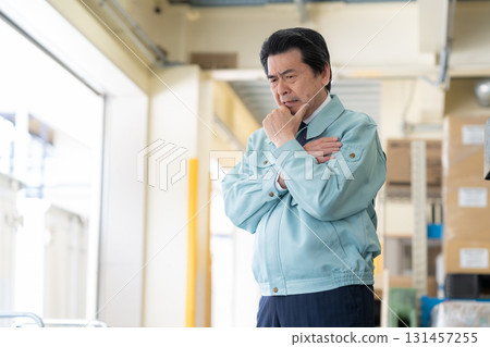 Senior male worker working in a warehouse Senior male worker working in a warehouse 131457255
