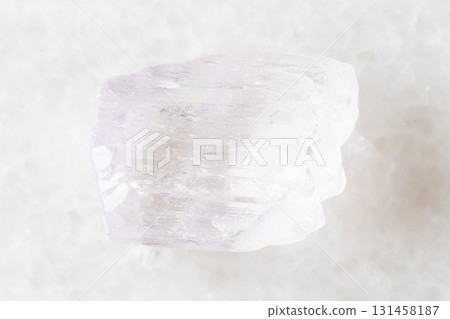 sample of rough kunzite mineral on white marble 131458187