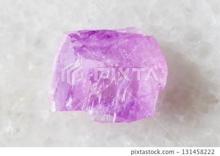 sample of rough kunzite crystal on white marble 131458222