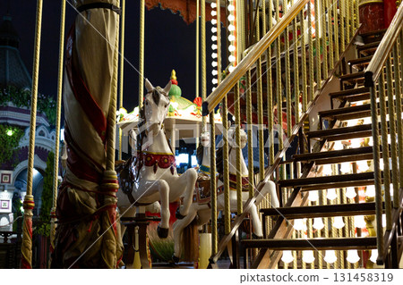 Vibrant carousel featuring beautifully decorated horse. The warm glow of the lights adds a magical touch to the festive scene, capturing the essence of joy, fun, and family moments at the fair 131458319