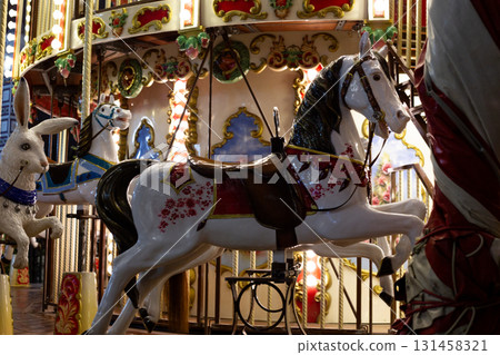 Vintage carousel featuring ornate horses and rabbit, illuminated by bright lights. Nostalgic amusement ride evokes joy and excitement, perfect for childhood memories, fun and festive celebrations Vintage carousel featuring ornate horses and rabbit, illuminated by bright lights. Nostalgic amusement ride evokes joy and excitement, perfect for childhood memories, fun and festive celebrations 131458321