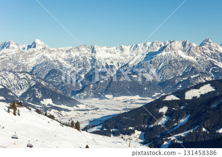 Scenic Saalbach-Hinterglemm-Leogang skicircus area snow-covered alpine mountains horizon sharp peaks illuminated sunlight. Valley forests ski slopes, chairlifts winter holiday activities white slopes 131458386