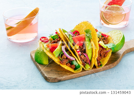 Tacos on a wooden board and Paloma cocktails, Mexican food and drink Tacos on a wooden board and Paloma cocktails, Mexican food and drink 131459043