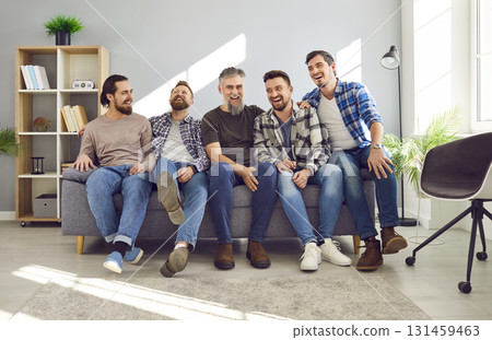 Happy, cheerful, smiling friends or father and adult sons sitting on the couch at home 131459463