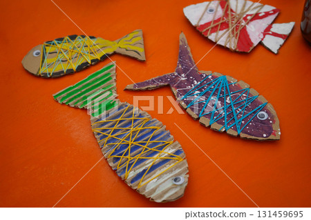 Make a cardboard fish using thread and paint, with detailed instructions, on an orange backdrop. Make a cardboard fish using thread and paint, with detailed instructions, on an orange backdrop. 131459695