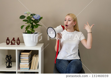 Woman expressing opinion with megaphone in home setting Woman expressing opinion with megaphone in home setting 131460039