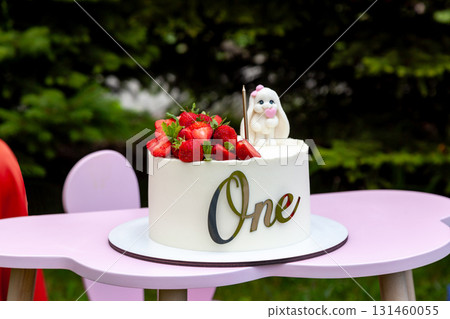 First birthday cake with strawberries and bunny topper 131460055