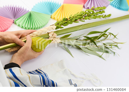 Jewish festival of Sukkot. Traditional symbols Etrog and Lulav in hands 131460084