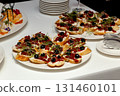 Appetizer bruschetta with olives, cheese and sprouts on buffet table 131460101
