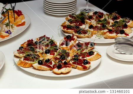 Appetizer bruschetta with olives, cheese and sprouts on buffet table Appetizer bruschetta with olives, cheese and sprouts on buffet table 131460101