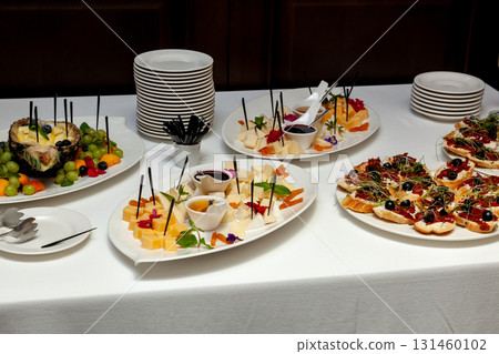 Elegant buffet table with assorted cheese, bruschetta and fresh fruits 131460102