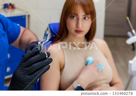 Dentist preparing injection for young woman during dental procedure Dentist preparing injection for young woman during dental procedure 131460278