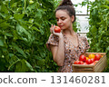 Woman with basket of fresh tomatoes in greenhouse 131460281