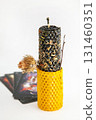 Black and yellow ritual candle with herbs on Tarot cards for luck and protection 131460351