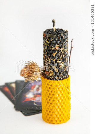 Black and yellow ritual candle with herbs on Tarot cards for luck and protection Black and yellow ritual candle with herbs on Tarot cards for luck and protection 131460351