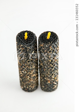 Decorative handmade candles with textured exterior and yellow wicks 131460352