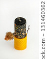 Natural hand-rolled beeswax candle with herbs on a light background 131460362