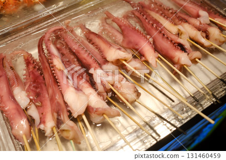 Grilled octopus skewers ready for serving at a lively street market during evening hours Grilled octopus skewers ready for serving at a lively street market during evening hours 131460459