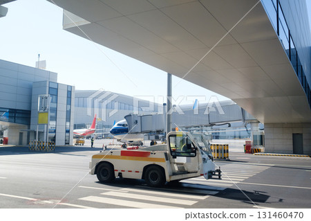 Busy airport scene with aircraft and ground support vehicle under clear blue sky in the afternoon Busy airport scene with aircraft and ground support vehicle under clear blue sky in the afternoon 131460470