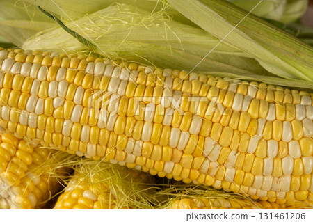 Macro shot of fresh raw corn cobs with green leaves. Macro shot of fresh raw corn cobs with green leaves. 131461206