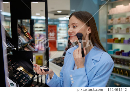 In a cosmetics store, a woman is skillfully applying makeup to her face 131461242