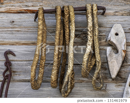 Riding old farmer tools on wooden cabin wall 131461979