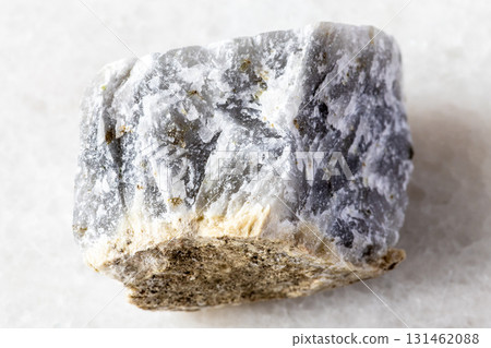 sample of raw melilite mineral on white marble 131462088