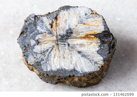 sample of raw chiastolite rock on white marble 131462099