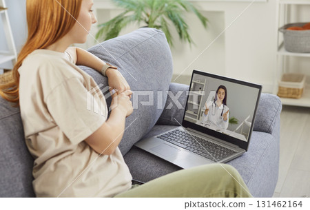 Sick young woman listening recommendations having online video call with a doctor at home. Sick young woman listening recommendations having online video call with a doctor at home. 131462164