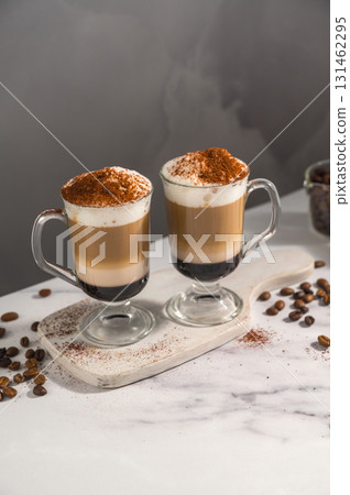 Layered coffee latte drink. Hot coffee drinks in glass mugs, grey background 131462295