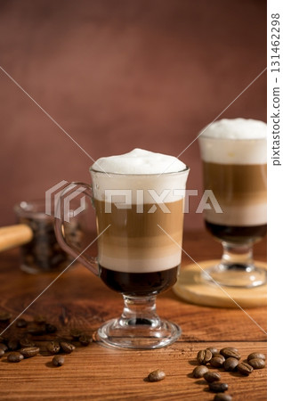 Layered coffee latte drinks. Hot coffee drinks in glass mugs, brown background 131462298