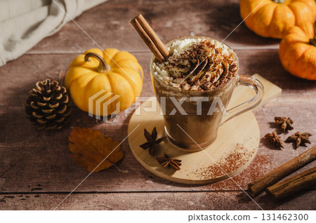 Pumpkin spice latte, coffee drink in glass cup with pumpkins, autumn hot drink 131462300