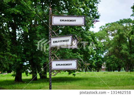 Dealing, merger and acquisition, business cooperation concept. Copy space. ENGAGEMENT written on a vintage signpost stands tall in a serene park 131462558
