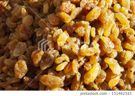 A heap of raisins. A pile of yellow raisins. A dried fruit background 131462581