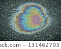 Oil slick on wet asphalt showing abstract iridescence and rainbow colors. 131462793
