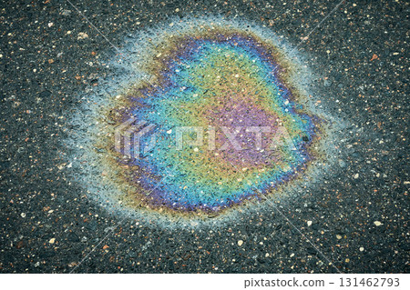 Oil slick on wet asphalt showing abstract iridescence and rainbow colors. Oil slick on wet asphalt showing abstract iridescence and rainbow colors. 131462793