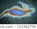 Oil slick creating abstract colorful pattern on wet dark asphalt. 131462796