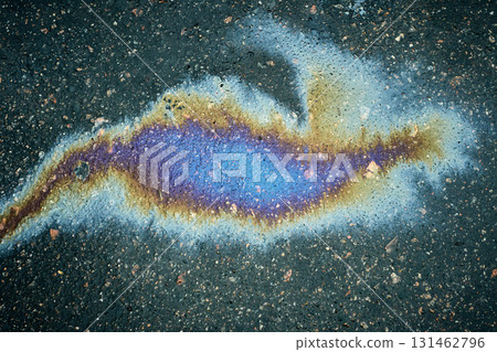 Oil slick creating abstract colorful pattern on wet dark asphalt. 131462796