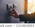 The young man's hand turned off the light switch. Energy saving concept. Hand Turning Off Light Switch. Saving Electricity with a Single Action. 131463003